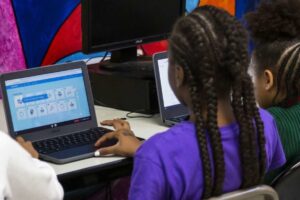 Nigerian students using laptops for e-learning in a classroom