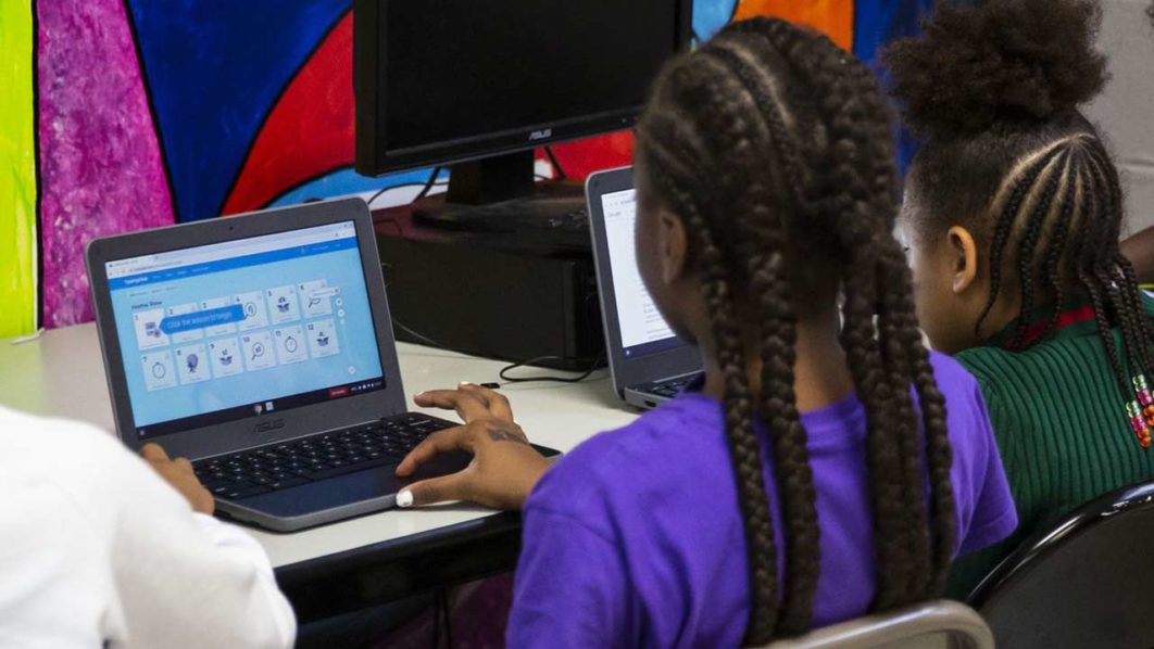 Nigerian students using laptops for e-learning in a classroom